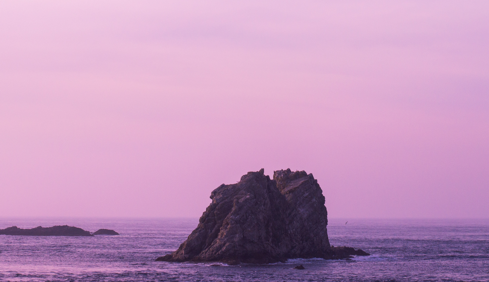 Giant rock against a pink sunset