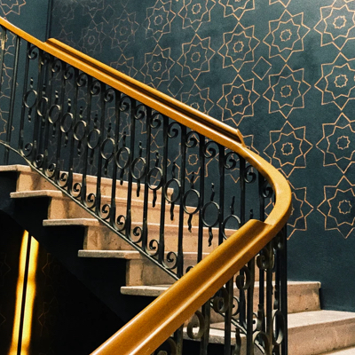 stairs in front of a dark wall with gold pattern